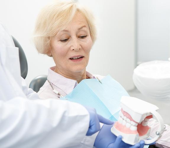 Dentist and patient looking at dental restoration model