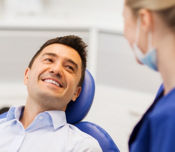 Man smiling at dentist during dental implant consultation