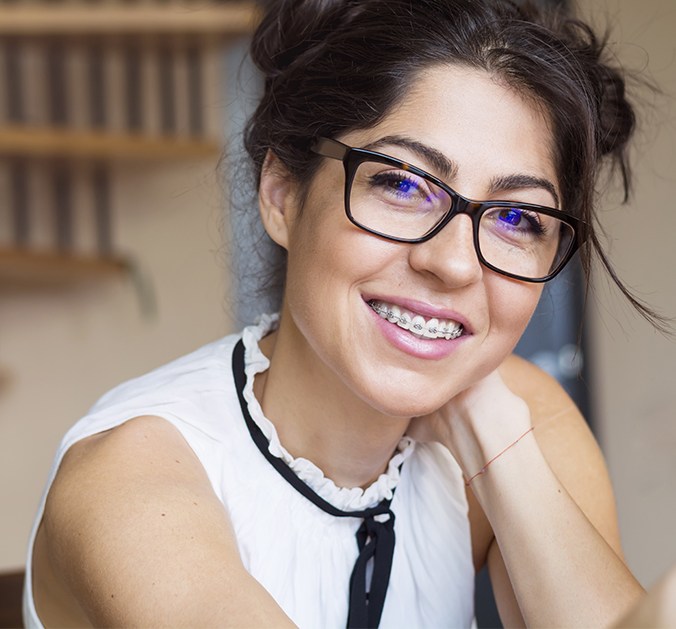 Woman with traditional braces smiling