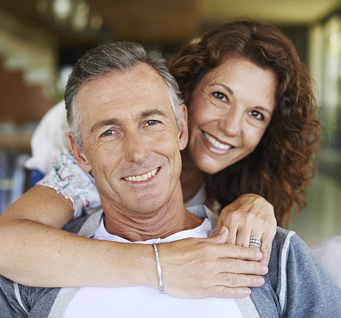 Man and woman smiling after restorative dentistry visit