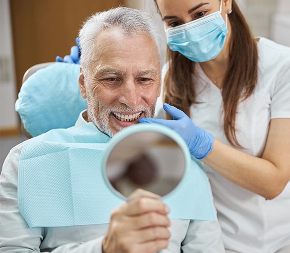 Man looking at smile after one visit dental restoration