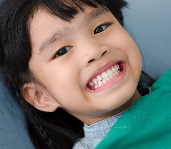 Child smiling after fluoride treatment