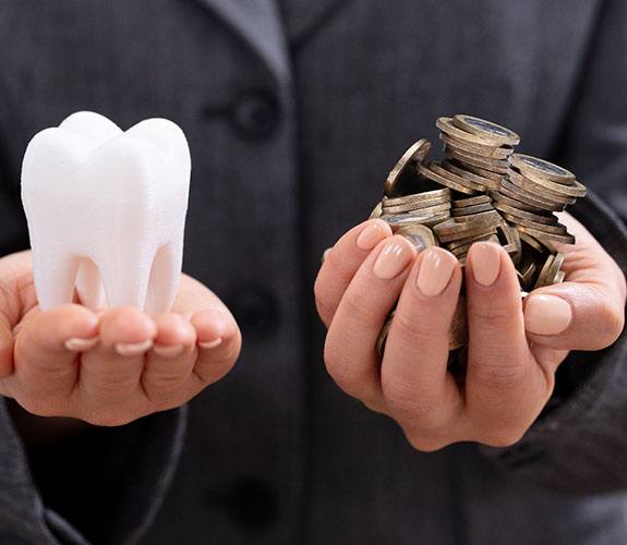 Hands holding tooth and coins