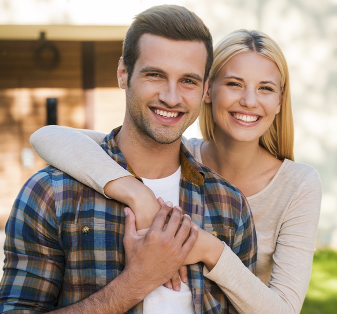 Man and woman smiling after dental crown and fixed bridge restoration