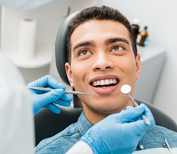 Patient receiving checkup to preventive dental emergencies
