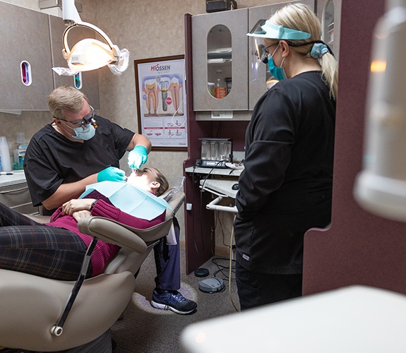 Woman talking to dentist about emergency dentistry treatment