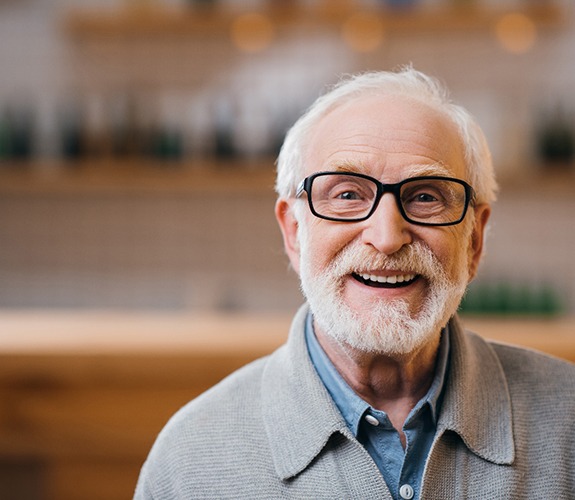 Senior man with glasses and implant dentures in Marion, IN