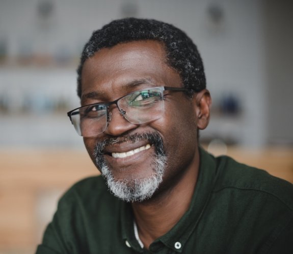 Older man with dental implant replacement teeth smiling