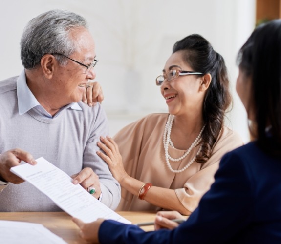 Man and woman discussing the cost of dental implant tooth replacement