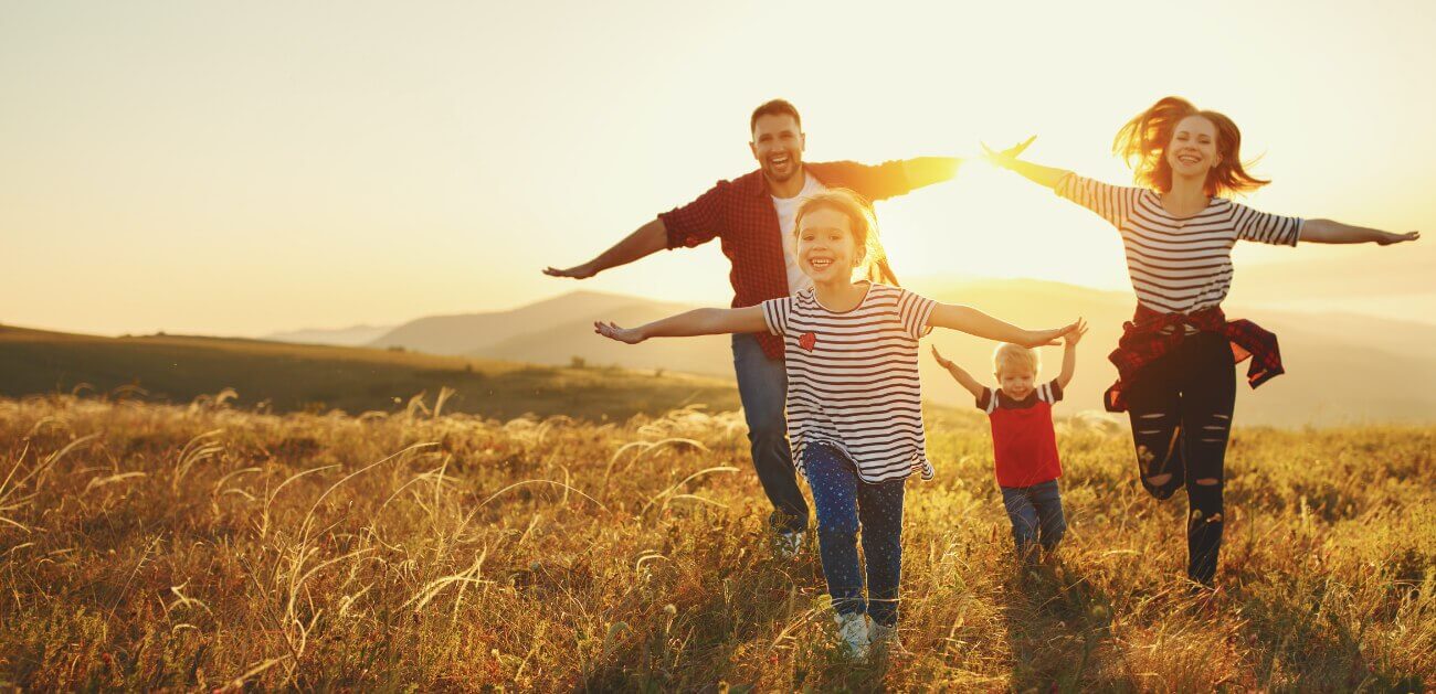 Family of three smiling outdoors after visiting their dentist in Marion