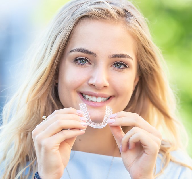 Woman placing Invisalign tray