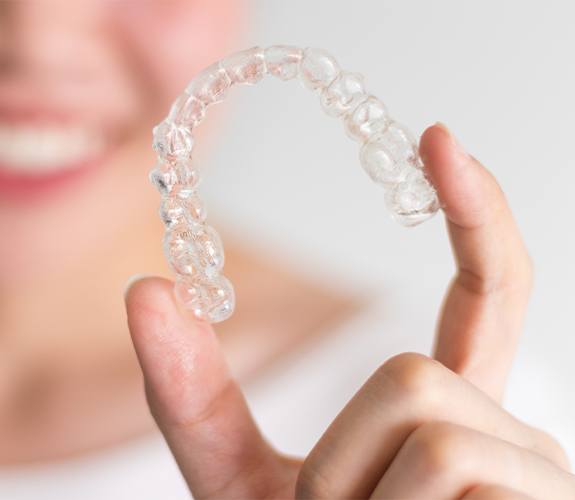 Hand holding an Invisalign tray