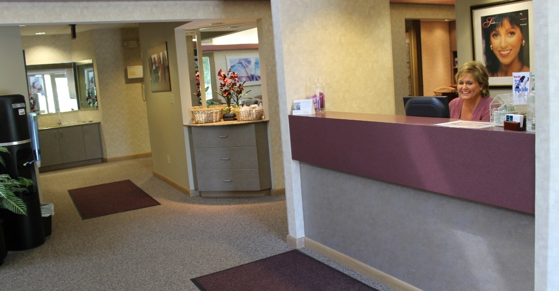 Dental team member smiling behind reception desk