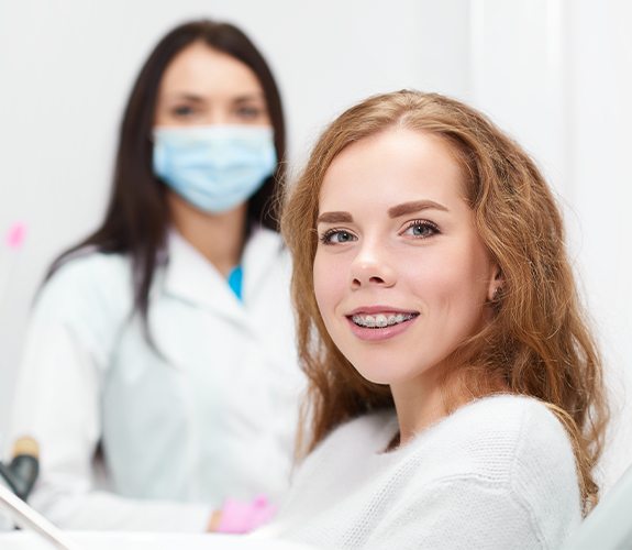 Woman with braces smiling during orthodontic visit