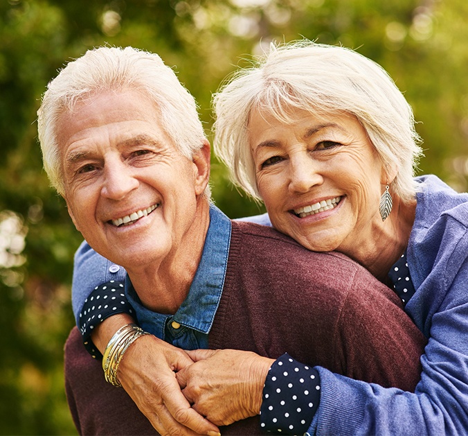 Man and woman sharing healthy smiles after gum disease treatment