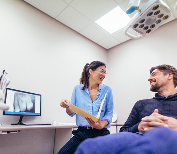 Dentist smiling at patient during exam