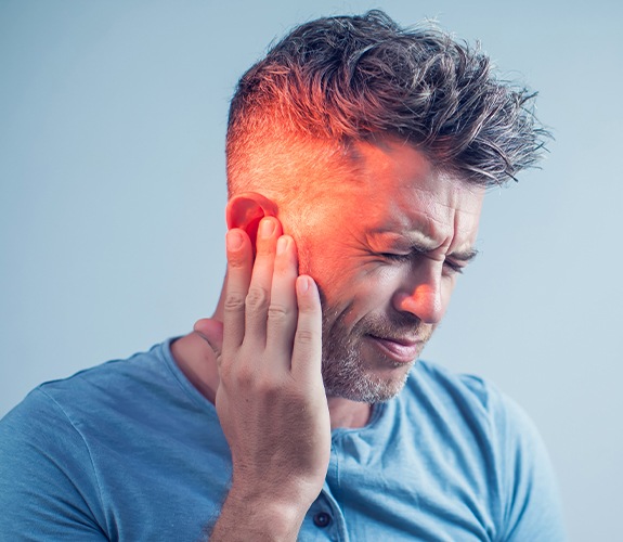 Man in need of root canal therapy holding jaw in pain