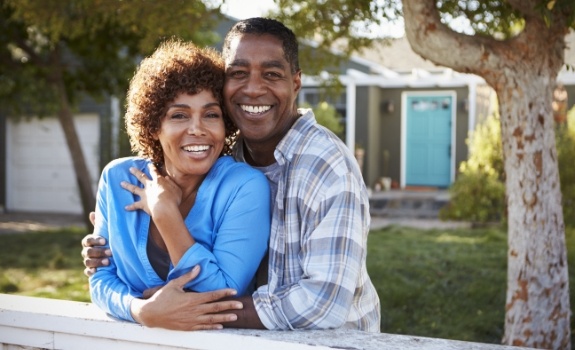 Man and woman sharing healthy smiles after restorative dentistry