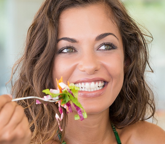 Woman with beautiful smile after porcelain veneer treatment