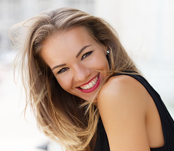 Woman sharing gorgeous smile after porcelain veneer treatment