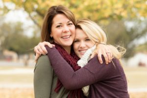 An older and younger woman hugging.